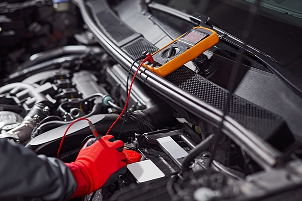 Technician testing battery with multimeter