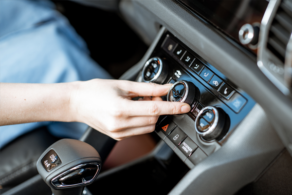 a hand turning the ac dial in a car 